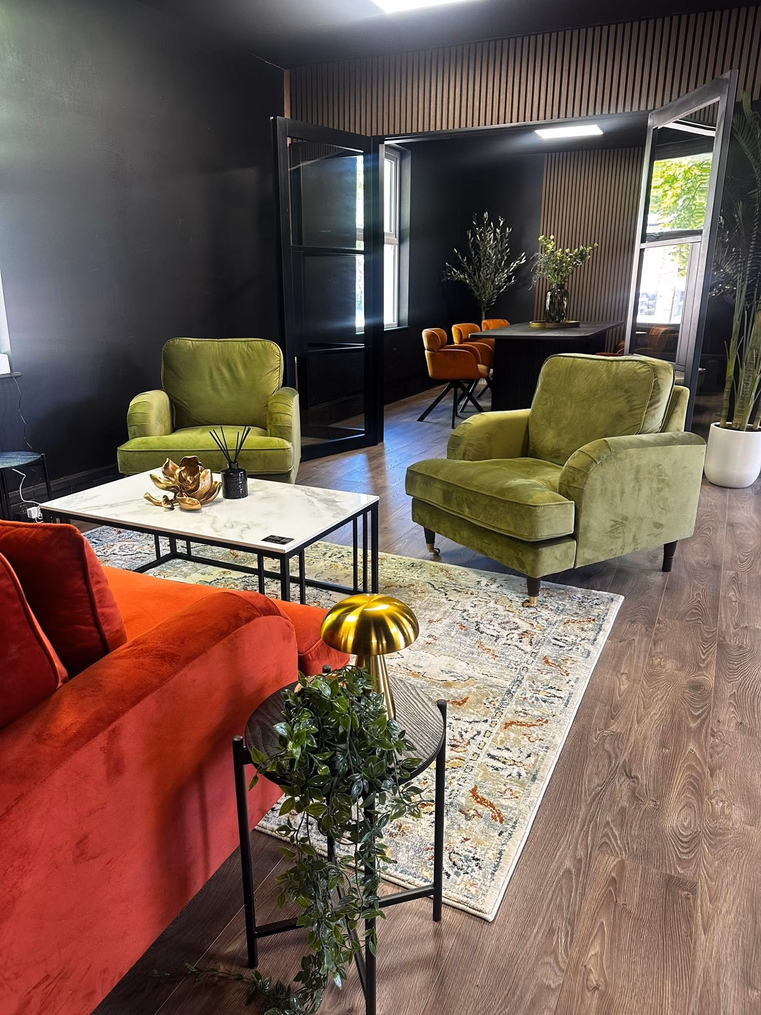 The social lounge at Howfen House with velvet armchairs